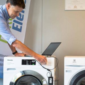 Marc Leyre stelt een diagnose bij een wasmachine van Miele en Electrolux met behulp van een sensor en computer.