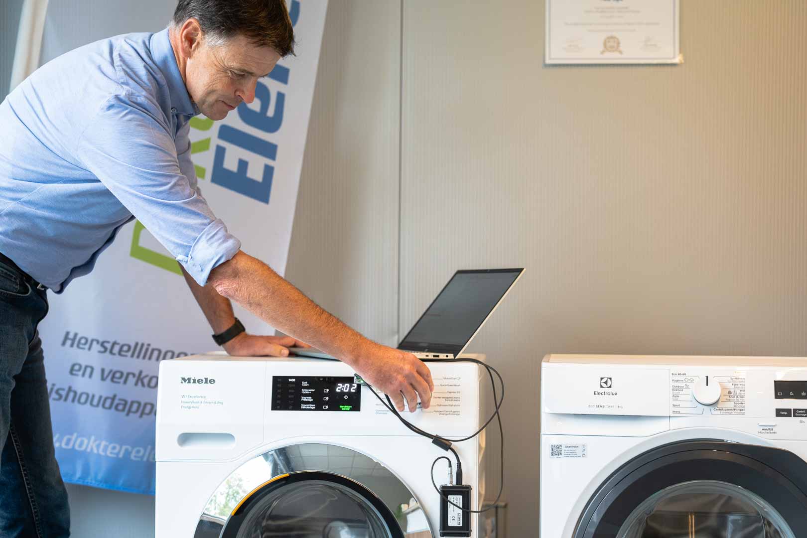 Marc Leyre stelt een diagnose bij een wasmachine van Miele en Electrolux met behulp van een sensor en computer.